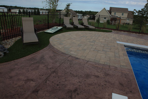 Stamped Concrete Pool Patio with Paver Designs and Synthetic Turf